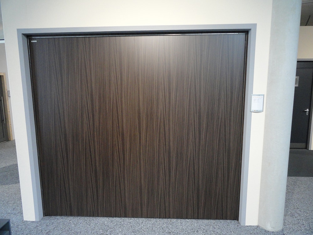 aqualock-garagenschwingtor-außen-mit-dunkler-holzverkleidung