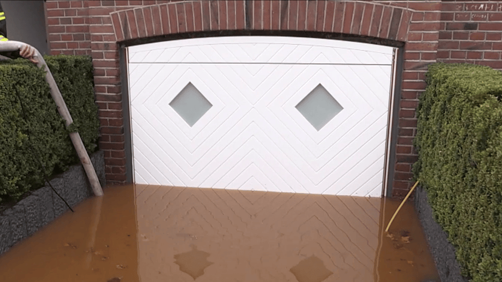 aqualock-garagenschwingtor-weiß-außen-mit-fenster-im-wassertest